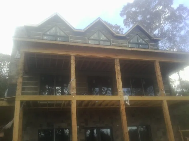Dormers and porch framing on a large log home under construction — Roof Coating work by our crew in Chambersburg