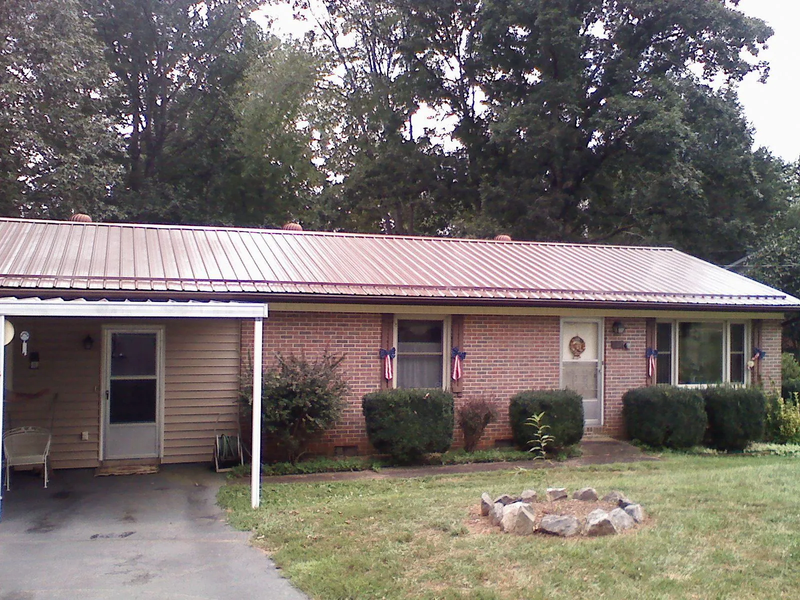 Bronze metal roof and carport on a brick ranch home — Roof Repair work by our crew in Chambersburg